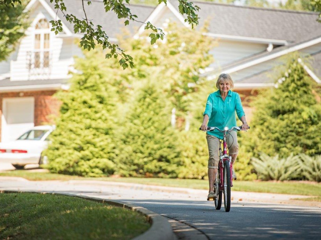 Woman riding a bike at Lake Pointe Landing community in Hendersonville, NC